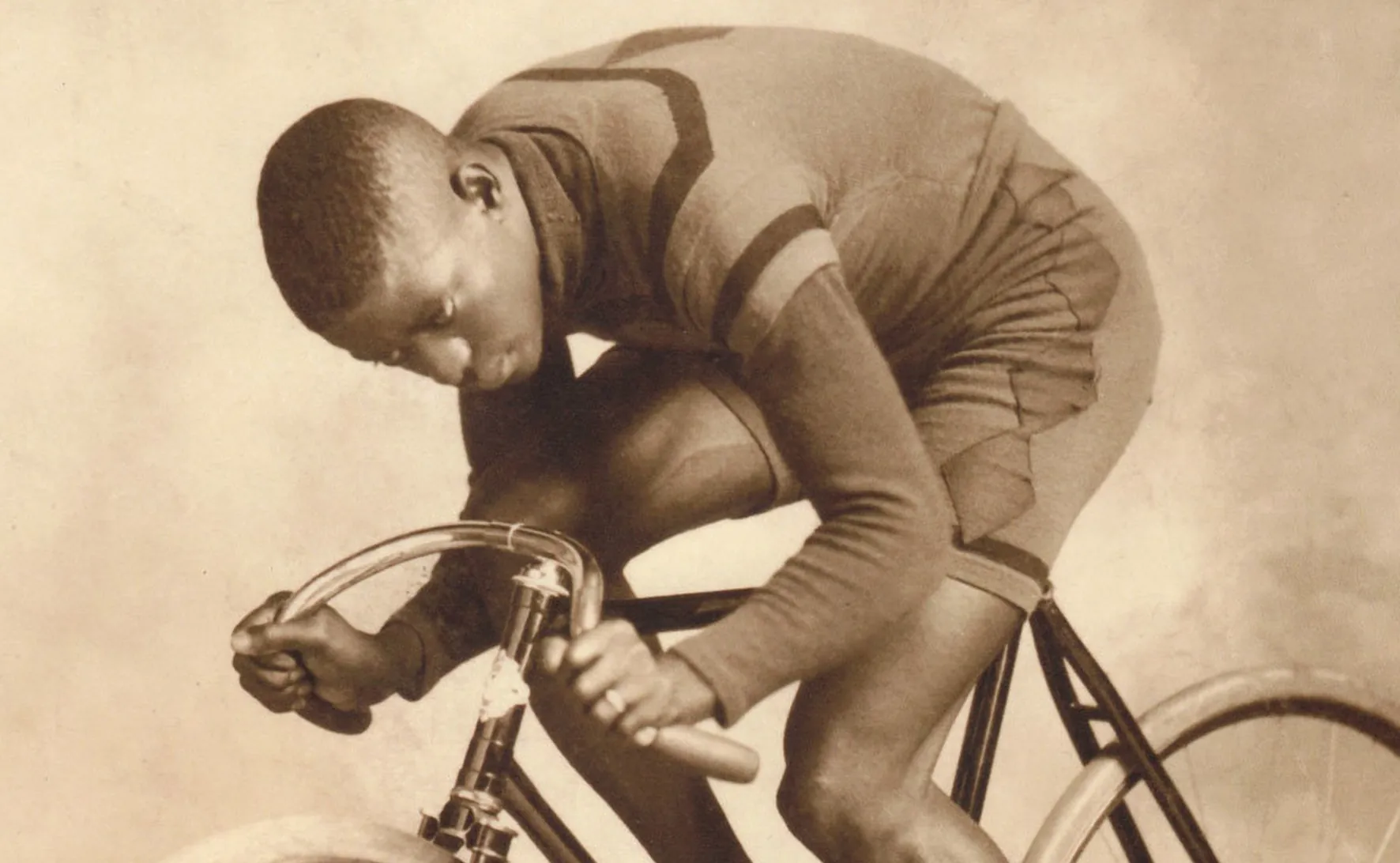 A period photograph of Marshall "Major" Taylor crouched in racing posture on a track bike
